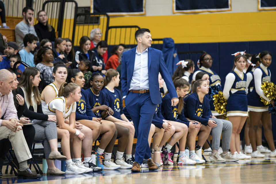 This photo provided by Scott Kerr shows Simsbury High School girls basketball coach Sam Zullo during a game earlier this season. Sam Zullo will coach for the Connecticut state high school title on Saturday, March 16, 2024, the same day his father Jim Zullo will coach the Northville High School girls in the New York state high school semifinals. (Scott Kerr via AP)