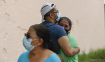 People embrace on he street as they wait for the all-clear to return to their apartment after an earthquake in Mexico City, Tuesday, June 23, 2020. The earthquake struck near the Huatulco resort in the Oaxaca state on Tuesday morning, swayed buildings in Mexico City and sent thousands fleeing into the streets. (AP Photo/Eduardo Verdugo)