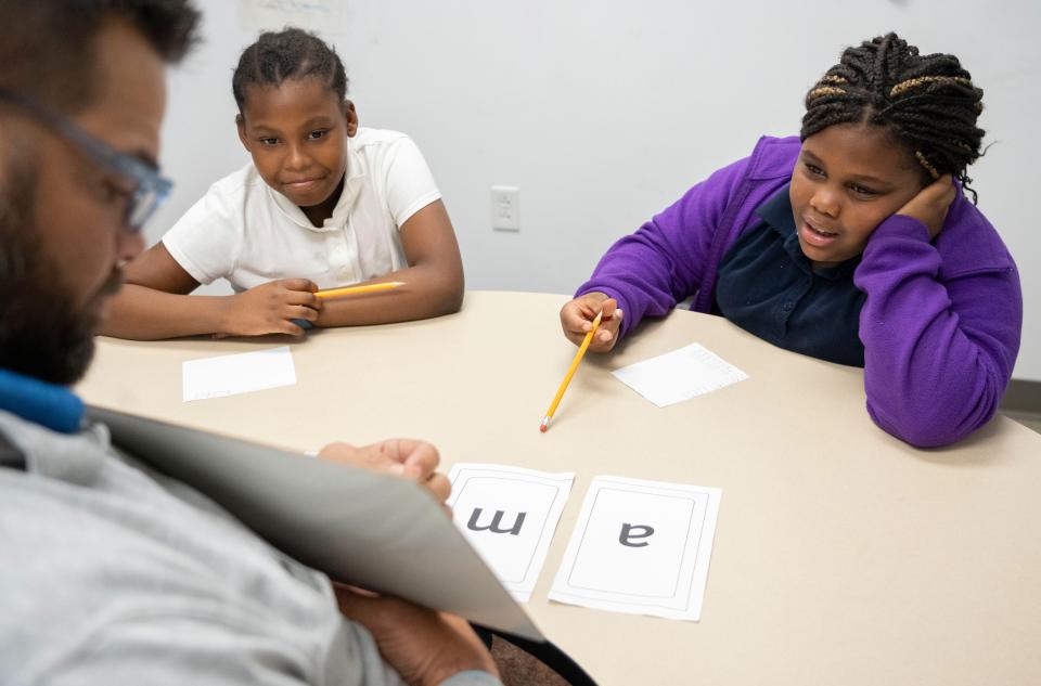 Beautiful Roberson, left, and Ca’drea Adkins work with tutor Matthew Anderson during a Circle City Readers tutoring session Thursday, Nov. 9, 2023, at Vision Academy at Riverside in Indianapolis. The third-graders meet with Anderson three times a week to practice literacy skills.