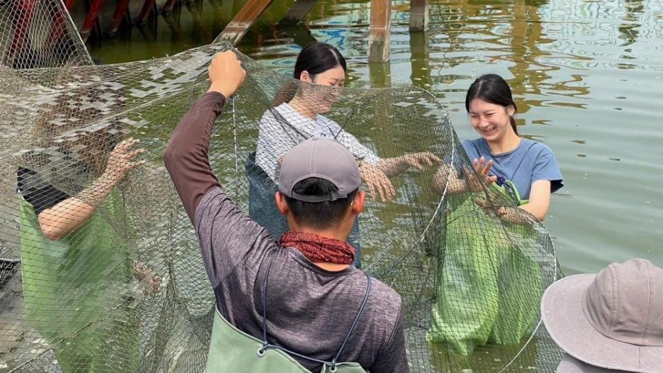 高雄大學推動食魚教育，師生換著「青蛙裝」下池，親身感受漁民飼養、撈捕作業辛勞。　（記者王正平攝）