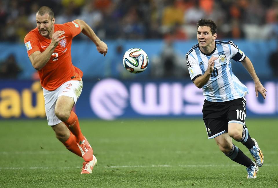 Ron Vlaar of the Netherlands (L) fights for the ball with Argentina's Lionel Messi during their 2014 World Cup semi-finals at the Corinthians arena in Sao Paulo July 9, 2014. REUTERS/Dylan Martinez