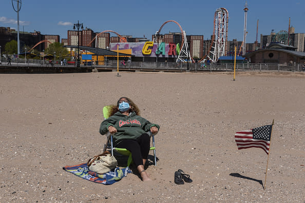 A person sunbathes while wearing a protective mask in the Coney Island neighbourhood in the Brooklyn borough in New York City. 