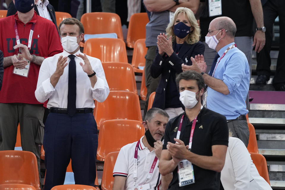 French President Emmanuel Macron, left, United States first lady Jill Biden, top right, and Paris 2024 president, and three-time Olympic champion, Tony Estanguet, bottom right, applaud as they watch a women's 3-on-3 basketball game between the United States and France at the 2020 Summer Olympics, Saturday, July 24, 2021, in Tokyo, Japan. The 2024 Paris Olympics emerges fully on Sunday, Aug. 8 from its unexpected extra year in the shadows with a formal handover from Tokyo. (AP Photo/Jeff Roberson)