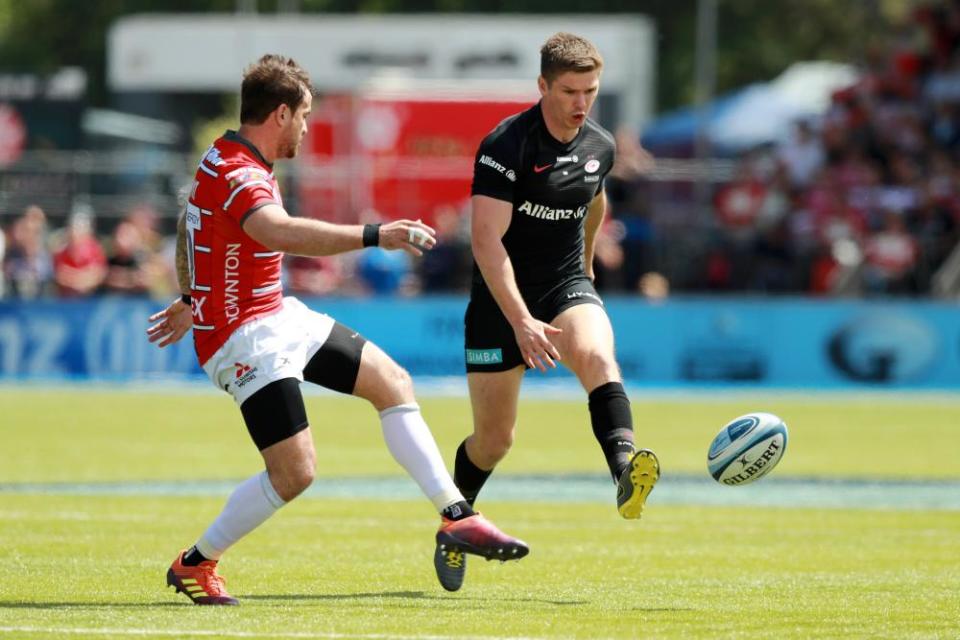 Owen Farrell of Saracens kicks the ball past Danny Cipriani.