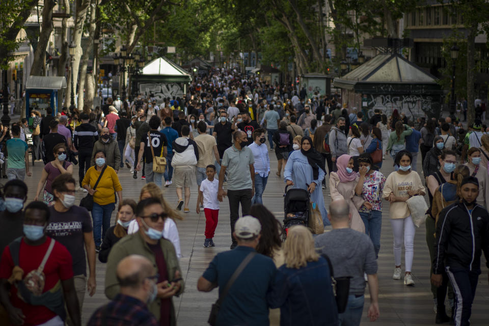 People wearing face masks to protect against the spread of Coronavirus walk along La Rambla in downtown Barcelona, Spain, Saturday, May 15, 2021. (AP Photo/Emilio Morenatti)