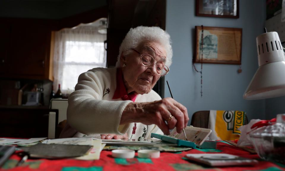 Germaine Smith, who turned 100 on Jan. 8, paints a greeting card using water colors while sitting at her kitchen table on Jan. 18, 2023, in Wrightstown, Wis.