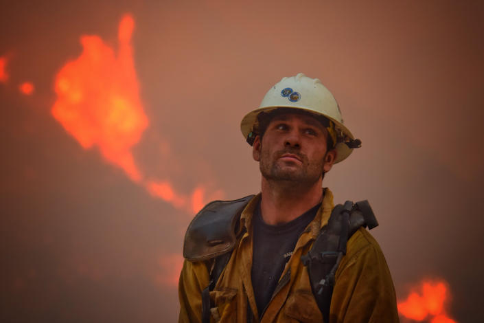 <p>County fire hand crew member Nikolas Abele keeps an eye on a hillside for any stray embers during a firing operation in Santa Monica Canyon in Carpinteria, Calif., Monday, Dec. 11, 2017. (Mike Eliason/Santa Barbara County Fire Department via AP) </p>