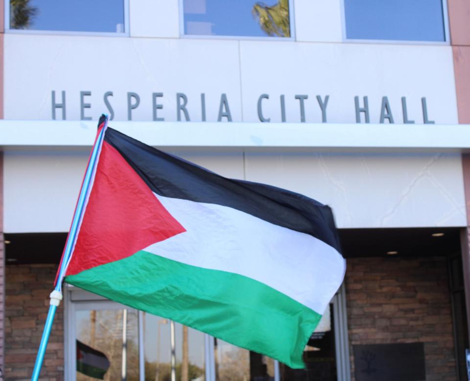Organization members fly the Palestine flag in front of the Hesperia City Hall