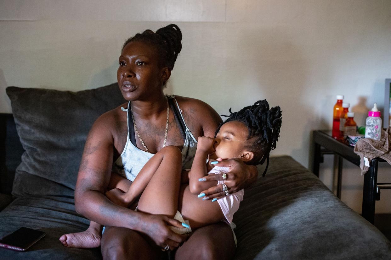 Christine Daniels holds her daughter, TeSharria, 5, as she recalls the struggles she had during her pregnancy and childbirth.