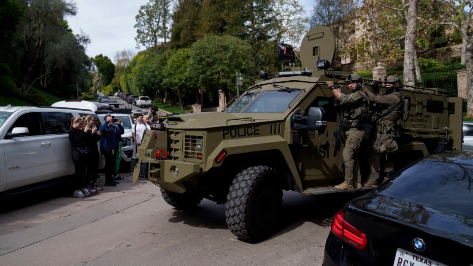 Law enforcement officers ride a vehicle near a property belonging to Sean "Diddy" Combs on Monday in Los Angeles. - Eric Thayer/AP