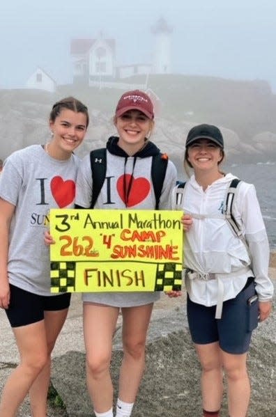 Mackenzie Webb, left, Katie Reidy, and Sarah Webb are all smiles after walking 26.2 miles, from Kennebunkport to the Nubble Lighthouse in York, to raise money for Camp Sunshine on Saturday, May 21, 2022.