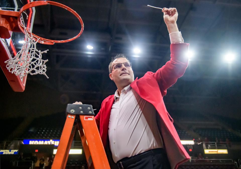 Bradley Braves head coach Brian Wardle holds up a piece of net for the crowd after cutting it down in celebration of winning the MVC championship with a 73-61 defeat of Drake on Sunday, Feb. 26, 2023 at Carver Arena.