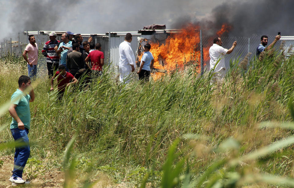 <p>Syrians refugees look on as a fire rages in a camp for refugees near the village of Qab Elias in the Lebanese Bekaa valley on July 2, 2017.<br> A massive fire in a camp for Syrian refugees in central Lebanon killed one person and wounded six others, the Red Cross said, adding that hundreds were evacuated. (Hassan Jarrah/AFP/Getty Images) </p>