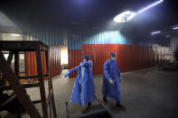 Workers put on personal protective suits before carrying the body of a COVID-19 victim for cremation in New Delhi, India, Wednesday, Sept. 16, 2020. India is now second in the world with the number of reported coronavirus infections with over 5.1 million cases, behind only the United States. Its death toll of only 83,000 in a country of 1.3 billion people, however, is raising questions about the way it counts fatalities from COVID-19. (AP Photo/Manish Swarup)