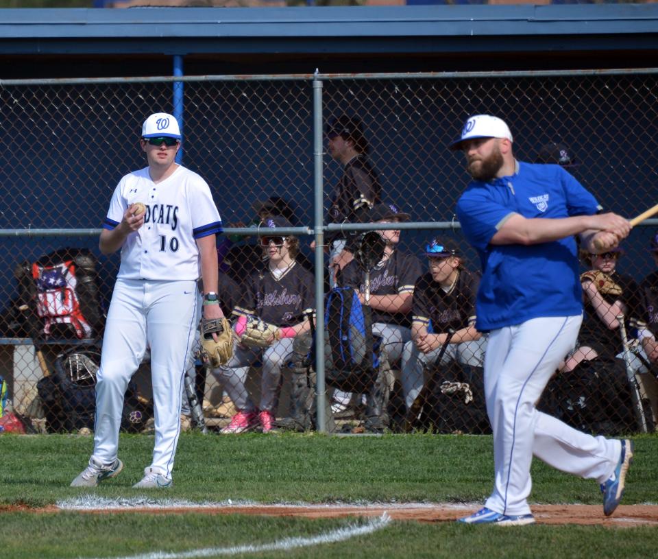 Williamsport senior Chris Downs assists coach AJ Jamison with pregame warmups prior to Monday's contest against Smithsburg.