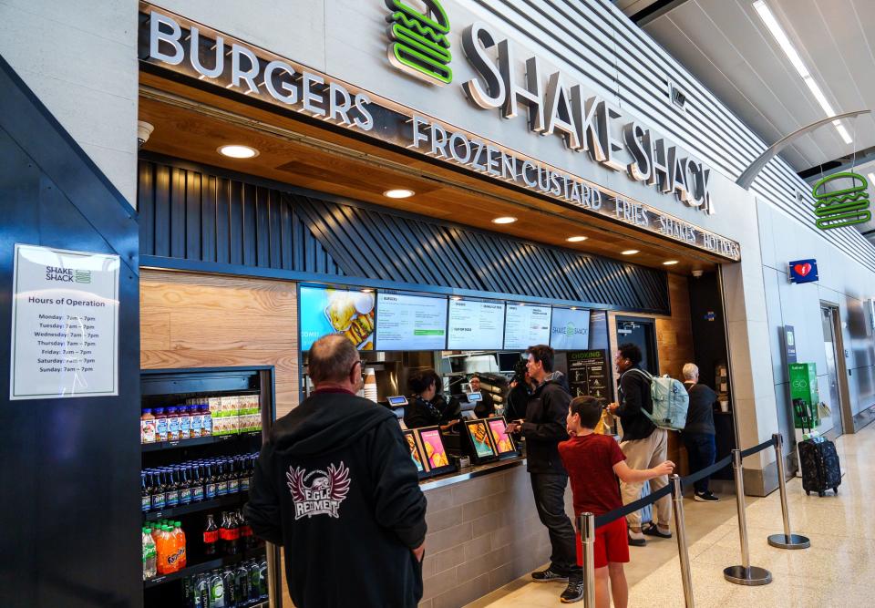 Air travelers grab some food at Shake Shack, a modern-day “roadside” burger stand, on Wednesday, Nov. 9, 2022, located insdie Concourse B at the Indianapolis International Airport.