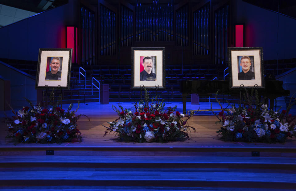 Portraits of Burnsville police officers Paul Elmstrand, 27, firefighter-paramedic Adam Finseth, 40, and officer Matthew Ruge, 27, left to right, are on display before a live stream of the memorial service for the three men at Prince of Peace in Burnsville, Minn., on Wednesday, Feb. 28, 2024. (Alex Kormann/Star Tribune via AP)