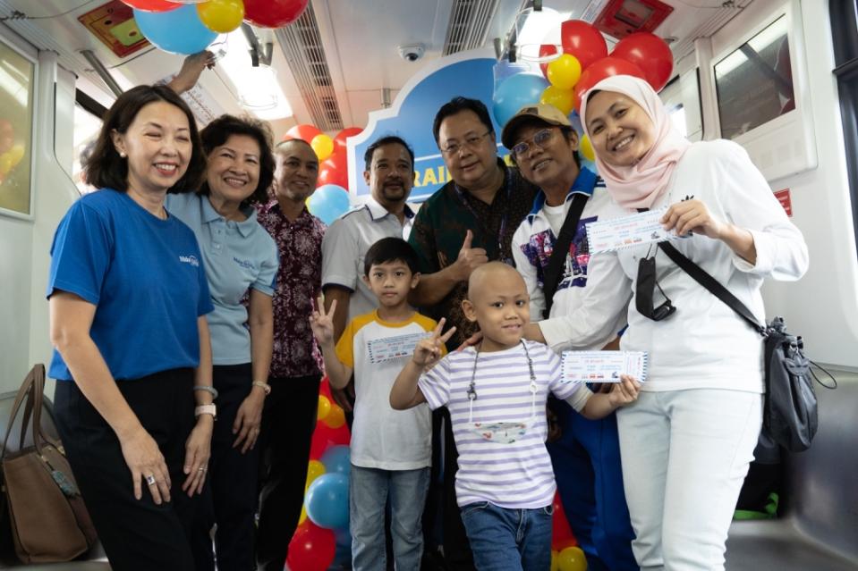 The Make-A-Wish Malaysia team (left), the Prasarana team (centre), and Ahmad’s parents (right) joyfully celebrated his birthday together. — Picture by Raymond Manuel
