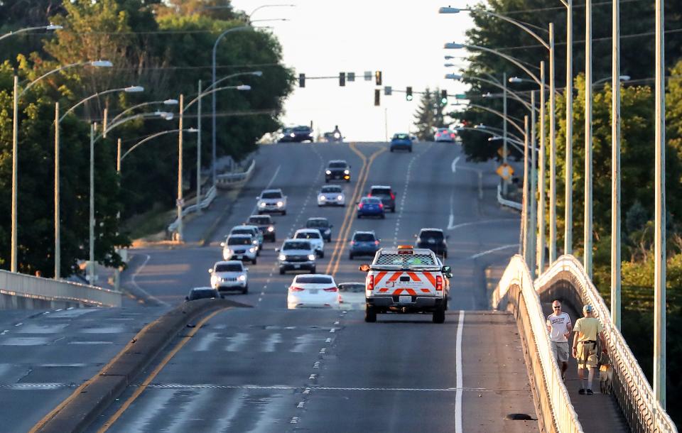 A pedestrian and a person walking a dog pass each other as the travel in opposite directions on the sidewalk of the east side of the Warren Avenue Bridge in Bremerton on Thursday, Aug. 3, 2023.