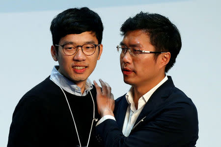Pro-democracy candidate Au Nok-hin (R) celebrates with disqualified lawmaker Nathan Law after winning in the Legislative Council by-election in Hong Kong, China March 12, 2018. REUTERS/Bobby Yip