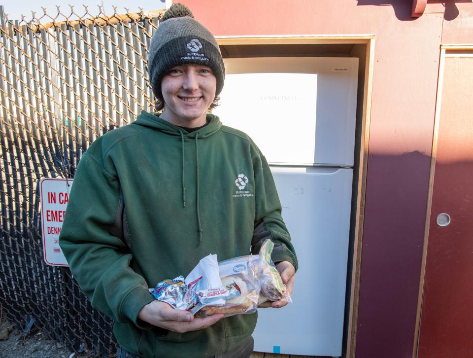 Terry O’Connor holds a bag lunch from the community refrigerator outside Superior Waste & Recycling on Kansas Street.