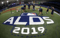 Members of the Tampa Bay Rays grounds crew spray-paint the ALDS logo on the field Sunday, Oct. 6, 2019, in St. Petersburg, Fla. The Rays take on the Houston Astros in Game 3 of a baseball American League Division Series on Monday. (AP Photo/Chris O'Meara)