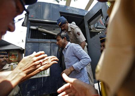 Policemen escort one of the four men convicted of raping a photojournalist outside a jail in Mumbai March 20, 2014. REUTERS/Mansi Thapliyal