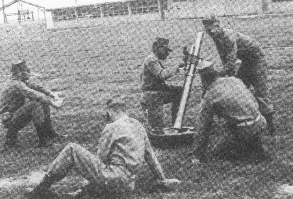 During training at Camp Pendleton in California, Fred Norris' crew works to set the sight on their mortar gun. Norris is kneeling in the middle of the frame.