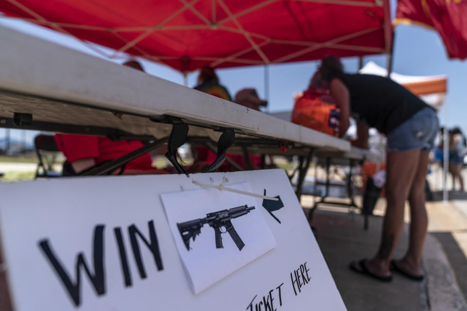 Barbie Rohde buys a raffle ticket to win an AR-15 rifle at a festival while volunteering for Mission 22, a nonprofit that is focused on ending military and veteran suicide, Saturday, June 10, 2023, in Jacksonville, Texas. Rohde is a conservative, a devoted fan of former President Donald Trump. She doesn’t like phrases like “gun control” and doesn’t believe in mandated gun restrictions. But something more needs to be done, she thinks. (AP Photo/David Goldman)