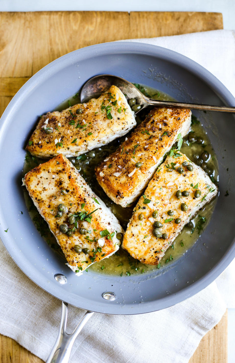 Halibut piccata in a skillet.