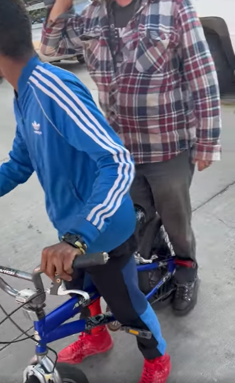 A still image taken from a video in which a white man was seen with his hand on a Black man's throat after a bicycle was allegedly stolen. The man released his hold after a bystander recording the interaction told him to let go. Milwaukee police said they are still investigating the incident.