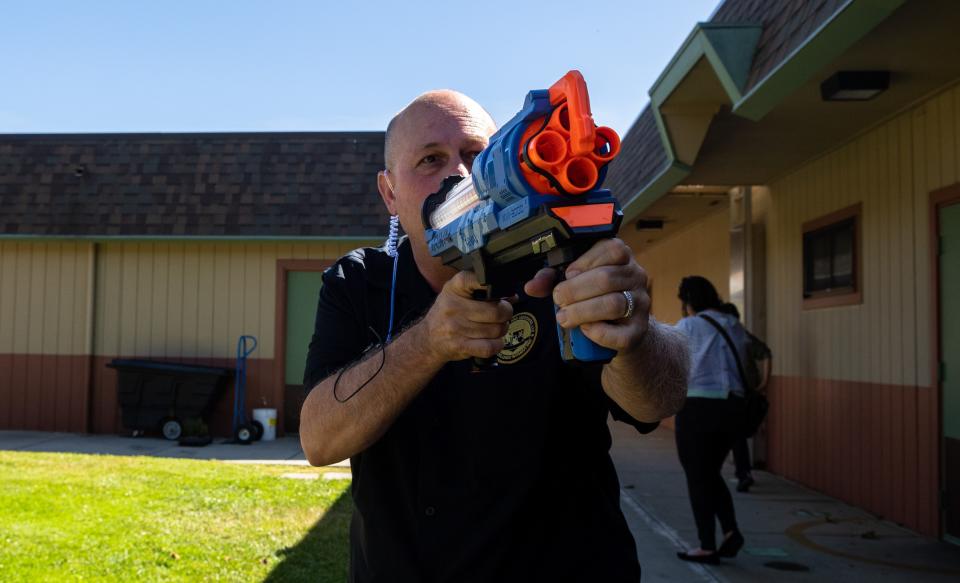 Michael C. Kimball, director of training & consulting at M.C. Kimball & Associates, LLC, holds a toy gun during an active shooter training hosted by Alisal Union School District at Virginia Rocca Barton School in Salinas, Calif., on Thursday, June 9, 2022. 