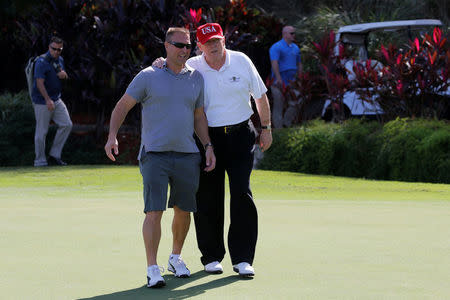 U.S. President Donald Trump walks with U.S. Coast Guard Chief Warrant Officer Gene Gibson, commanding officer of the Lake Worth Inlet Station, as Trump plays host to members of the U.S. Coast Guard he invited to play golf at his Trump International Golf Club in West Palm Beach, Florida, U.S., December 29, 2017. REUTERS/Jonathan Ernst