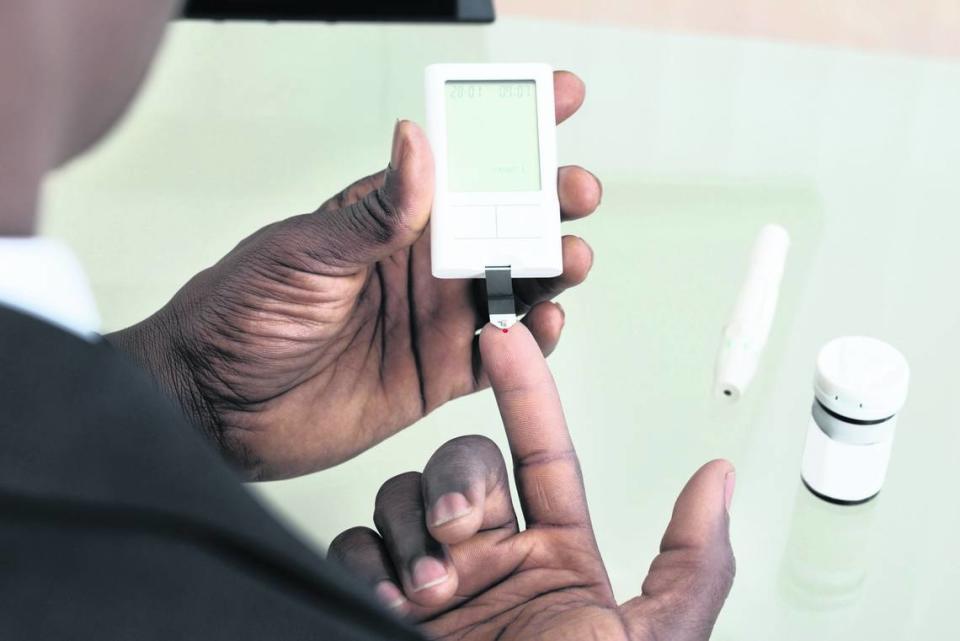 A patient measures their glucose levels with a blood test via a glucometer