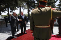 Secretary of State Mike Pompeo center, is welcomed to the Presidential Palace in Kabul, Afghanistan, by Afghan President Ashraf Ghani's Chief of Staff Abdul Salam Rahimi, left, Tuesday, June 25, 2019, during an unannounced visit. (AP Photo/Jacquelyn Martin, Pool)