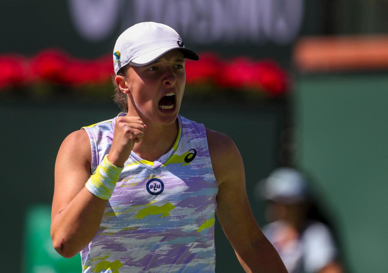 Iga Swiatek of Poland celebrates a game win against Maria Sakkari of Greece during the WTA singles final at the BNP Paribas Open at the Indian Wells Tennis Garden in Indian Wells, Calif., Sunday, March 20, 2022. 