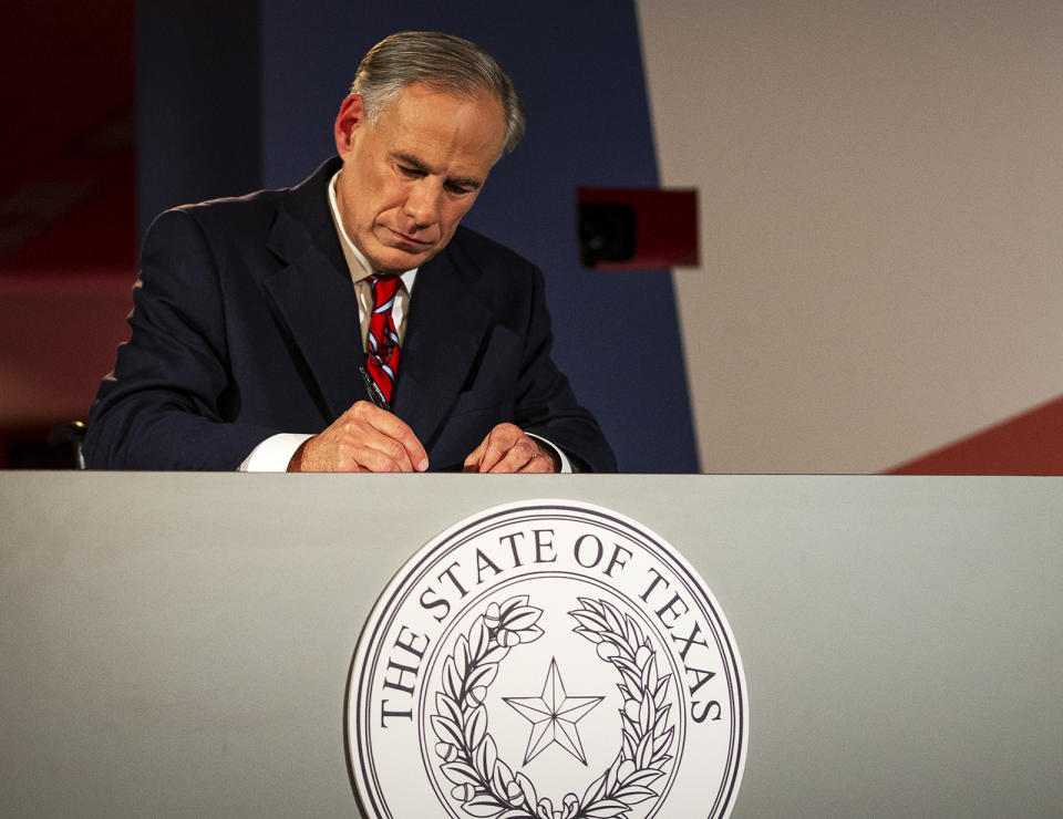 Texas Governor Greg Abbott writes notes before a gubernatorial debate against his Democratic challenger Lupe Valdez at the LBJ Library in Austin, Texas, on Friday, Sept. 28, 2018. (Nick Wagner/Austin American-Statesman via AP, Pool)