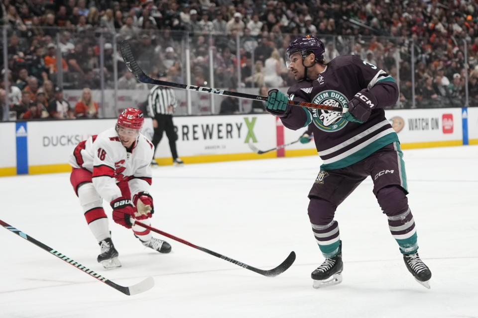 Anaheim Ducks' Sam Carrick (39) and Carolina Hurricanes' Jack Drury (18) watch as the puck hit by Carrick enters the net for a goal during the first period of an NHL hockey game, Sunday, Oct. 15, 2023, in Anaheim, Calif. (AP Photo/Jae C. Hong)