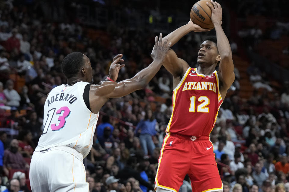 Atlanta Hawks forward De'Andre Hunter (12) takes a shot against Miami Heat center Bam Adebayo (13) during the first half of an NBA basketball game, Monday, March 6, 2023, in Miami. (AP Photo/Wilfredo Lee)