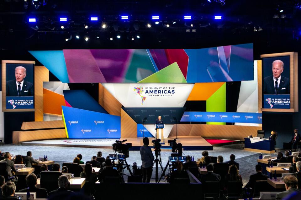 Cameras and media watch as President Biden speaks onstage