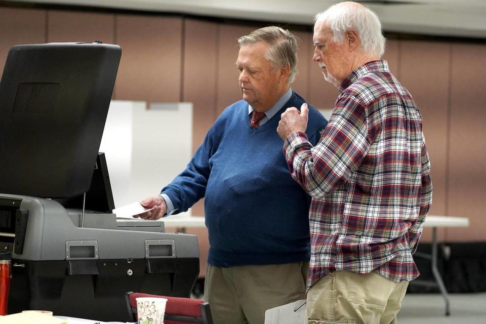 48th Precinct Official Ed King, right, assists voter Dennis Guthrie, left, as he casts his ballot into the Tabulator after voting at Providence United Methodist Church on Tuesday, March 3, 2020. Voters at the precinct now vote using the new ExpressVote machine where they mark their ballots and cast them in the Tabulator. Precinct Chief Judge Jane Pasquini says that the machines are quick, quiet and everyone seems to like them.