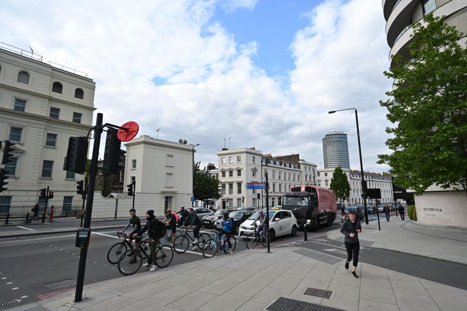 People on bicycles wait in front of traffic on a road in London on May 12, 2020, during the novel coronavirus COVID-19 pandemic. - The British government on Monday published what it said was a "cautious roadmap" to ease the seven-week coronavirus lockdown in England, notably recommending people wear facemasks in some public settings. (Photo by JUSTIN TALLIS / AFP) (Photo by JUSTIN TALLIS/AFP via Getty Images)