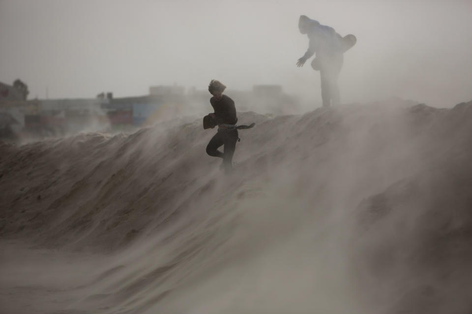 <p>Kids play on man-made sand hill to block high waves ahead of the upcoming storm in Tel Aviv’s beach front, Israel, Jan. 6, 2015. (Photo: Oded Balilty/AP) </p>