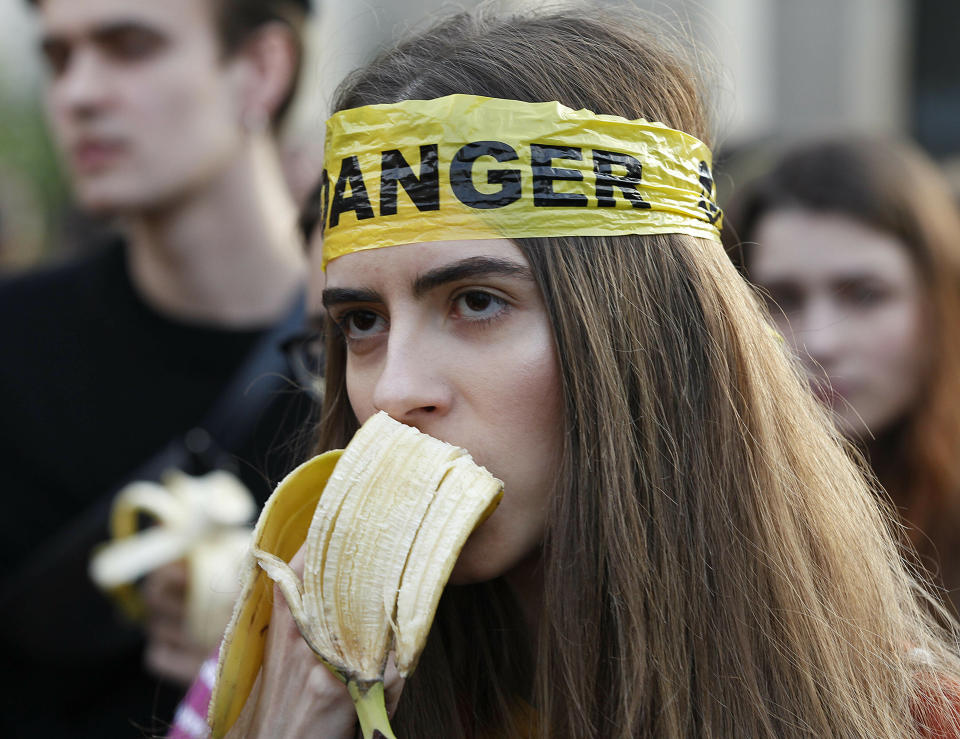 People with bananas demonstrate outside Warsaw's National Museum, Poland, Monday, April 29, 2019, to protest against what they call censorship, after authorities removed an artwork at the museum featuring the fruit, saying it was improper. (AP Photo/Czarek Sokolowski)