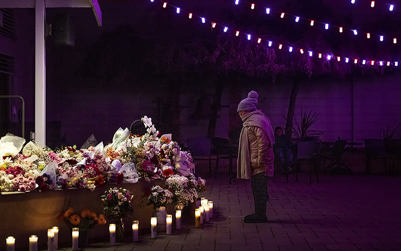 A woman stands at a growing memorial for victims of Monday’s mass shooting in Half Moon Bay, Calif., on Jan. 25. Several memorials have been left in town and at the sites where the farmworkers were killed. <em>Carlos Avila Gonzalez/San Francisco Chronicle via AP</em>