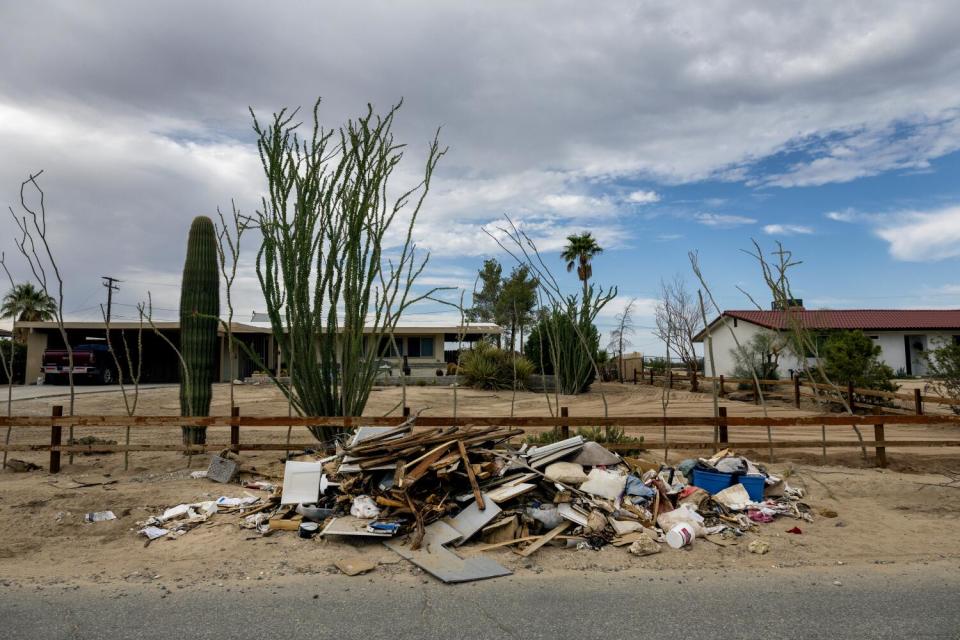 Debris is piled next to desert plants in front of homes in Twentynine Palms.