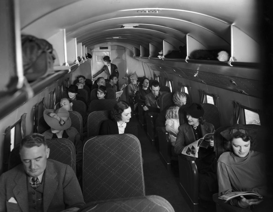 Passengers sitting in their seats inside the cabin of a 21-passenger airplane making daily trips between New York City and Chicago circa 1935.&nbsp;