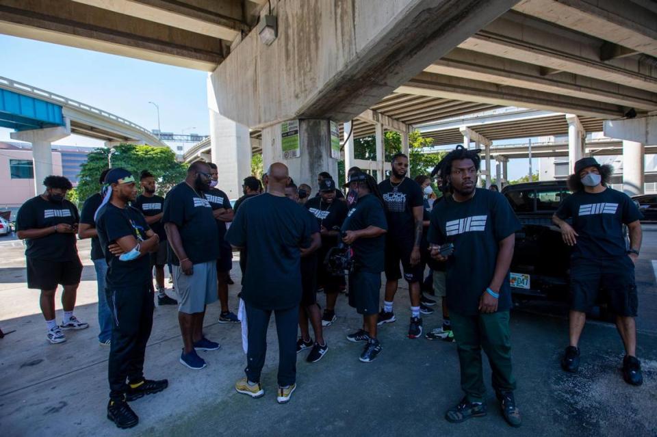 Members of Black Men Build gather for instructions while they volunteer during a donation and feeding event hosted by The Smile Trust, Inc. near Southwest 2nd Avenue and Second Street in Downtown Miami, Florida, on Sunday, October 17, 2021. Black Men Build is a platform for black men to “engage this country as an organized force” and volunteer their time to impact the community.