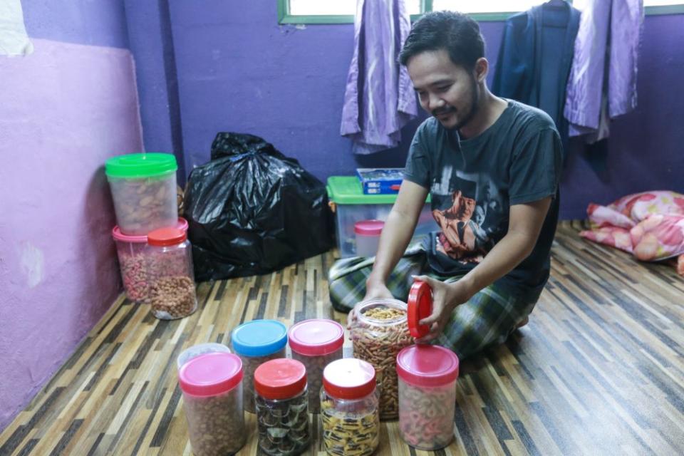 Abdul Rahman with some Raya treats... it will be a low-key celebration this year.  — Picture by Ahmad Zamzahuri