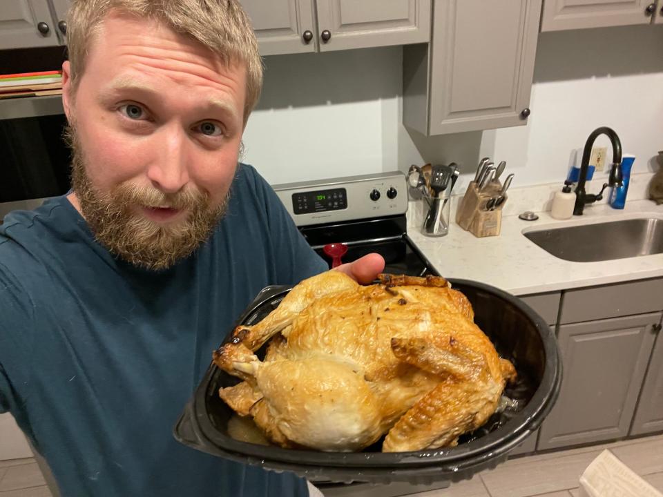 The writer holds a Kroger rotisserie chicken in container